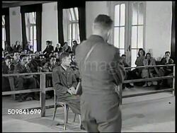 1945: MILITARY TRIBUNAL: STRASSER: MS German Nazi Franz Strasser & interpreter receiving question about victims from prosecutor, defense attorney standing FG, asking question, interpreter translating answer. MS U.S. War correspondents conferring. Instructional Video