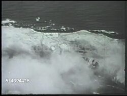 1943: ALEUTIAN ISLANDS CAMPAIGN: KISKA BOMBING: VS Flying over Kiska island, United States Army Consolidated B-24 Liberator bomb bay doors opening, pilots aiming, artillery bombs dropping away, clouds. WWII, World War II, Pacific Front, Alaska Instructional Video