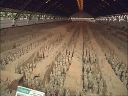 Tilt down from ceiling to WA Terracotta Army, Museum of Qin, Xian, China Stock Footage