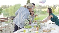 Woman serving cake to multi-generation family in backyard Stock Footage