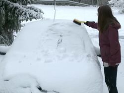  MS Young woman removing snow from car / Saarburg, Rhineland-Palatinate, Germany Stock Footage