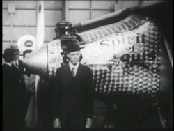 B/W 1927 Charles Lindbergh in suit standing in front of Spirit of St. Louis airplane Stock Footage