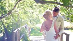 Bride and groom hugging under windy tree Stock Footage