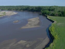 Following a winding river surrounded by trees Stock Footage