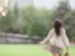 MS SLO MO TU Shot of young woman in skirt and barefoot, turns and runs away on grass / Portland, Oregon, United States  Stock Footage