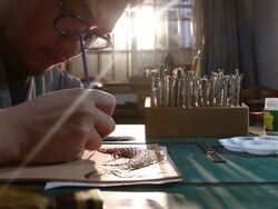 leatherworker paint fish pattern on leather Stock Footage