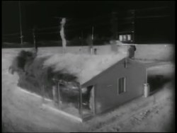 B/W 1955 SOLARIZED high angle house exploding during atomic bomb explosion test / Nevada Stock Footage