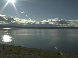 Pan Left Shot Mansarovar Lake with sun flare and clouds Lhasa Tibet China Stock Footage