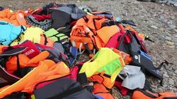 Life jackets and remains of boats left by Syrian migrants fleeing the war and escaping to Europe, landing on the Greek island of Lesvos on the north coast at Efthalou. Up to 4,000 migrants a day are landing on the island and overwhelming the authorities. T Stock Footage