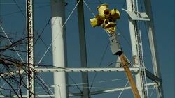 A yellow tornado siren leans against the legs of a water tower following a tornado. Stock Footage