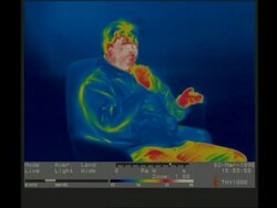 Thermographic image, MCU man sitting in armchair smokes cigarette Stock Footage