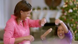 Mother and daughter have fun sprinkling flour on cookie dough in the kitchen (dolly-shot) Stock Footage