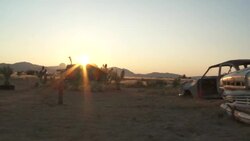 The golden hour sun shines on derelict cars in the Namib Desert. Stock Footage