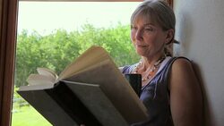 Senior woman reading book and drinking coffee Stock Footage