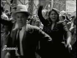 1943: MEXICO AN ALLY: CU Movie poster 'El Grito de Guerra' (To the Cry of War). MS Mexicans in parade cheering. WS Parade Mexican banners, flags, crowds. HA WS Mexicans walking w/ raised peace sign. CU Top of Presidential Palace building. WWII Instructional Video