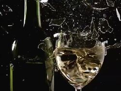 MS SLO MO Shot of Glass of white wine breaking and splashing against black background / Calvados, Normandy, france Stock Footage