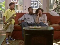 MS, couple listening to son (6-7) play saxophone in living room, Westfield, New Jersey, USA Stock Footage