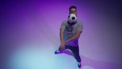 young male soccer freestyler juggling a ball around his head Stock Footage