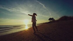 Jogging on the beach: jumping jack at sunset Stock Footage