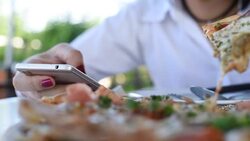 Woman using mobile phone with eating pizza Stock Footage