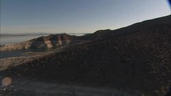 An aerial view shows rivers, canyons and mountains surrounding Hoover Dam. Stock Footage