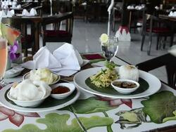 MS Being serve dish of chicken sate, fried chicken skewer with steamed rice on hot plate, kerupuk crackers, watermelon juice and balinese food at Asia / Ubud, Bali, Indonesia Stock Footage