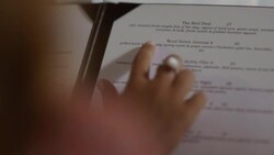 Over the shoulder woman points and reads restaurant menu Stock Footage