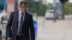 Financial advisor shakes hands with restaurant owner on street outside of business Stock Footage