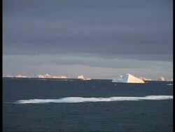 WA icebergs scattered in sea, reflecting orange light, edited sequence, Antarctica Stock Footage