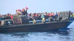 Royal Navy rescuing boat of migrants News Clip