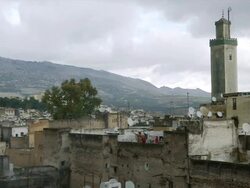 WS View of ornate mosque tower reaching high above old houses and satellite dishes attached to nearby houses / Fez, Fes-Boulemane, Morocco Stock Footage