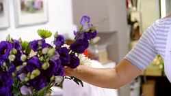 Smiling florist talking on cell phone in flower shop Stock Footage