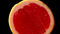 Blood grapefruit slowly rotating with black background Stock Footage