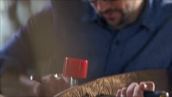 Craftsman mounts trucks on custom wooden skateboard in studio workshop Stock Footage