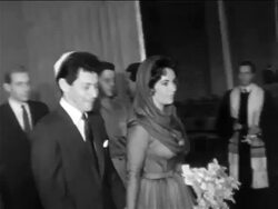 B/W 1959 PAN Elizabeth Taylor + Eddie Fisher in yarmulke walking from civil ceremony / newsreel Stock Footage