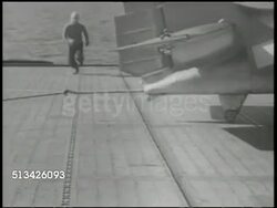 1940s: UNITED STATES NAVY: VS U.S. Navy signal officer signaling on aircraft carrier deck, fighting airplane landing on deck runway, crew unhooking arresting gear from tailhook, crew repositioning arrestor gear. WWII, World War II, Pacific Front Instructional Video