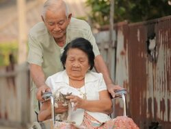 Senior man pushing her disabled wife on wheelchair Stock Footage