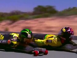 wide shot tracking shot zoom in to close up behind two street lugers speeding on mountain road Stock Footage