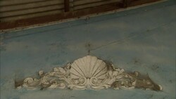 Dried flotsam clings to a cracked decorative sculpture on a flood-damaged structure. Stock Footage