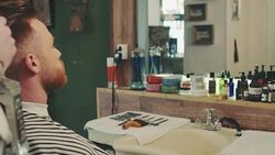Barber preparing man for haircut Stock Footage