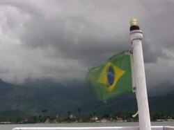 Brazilian flag on boat rear, Parati shore background - HD Stock Footage