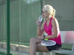 A tennis player drinking water between matches. - Slow Motion Stock Footage