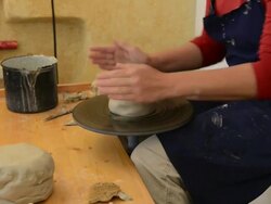 MS Shot of female potter shapes pot from lump of clay on potterwheel at pottery / Landshut, Bavaria, Germany Stock Footage