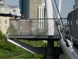 WS SLO MO Man balances body on railing and two other men perform flips on bridge / Denver, Colorado, United States Stock Footage