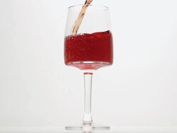 CU SLO MO Shot of Pink wine being pour into glass against white background / Calvados, Normandy, France Stock Footage