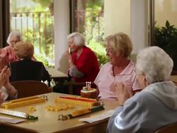 "MS PAN Care giver bringing birthday cake and senior citizen blowing candles / Laguna Woods, CA, United States " Stock Footage