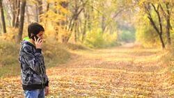 boy teenager walking through the woods and use the phone Stock Footage