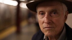 Old man stares at camera on subway platform as train arrives Stock Footage
