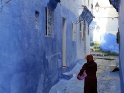 Local female visiting a traditional blue home in the village of Chefchaouen, Morocco, Africa Stock Footage