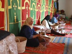 MS Shot of several woman sitting down with beautiful fabrics on walls and cracking almonds to make argon oil / casablanca, centro, morocco Stock Footage